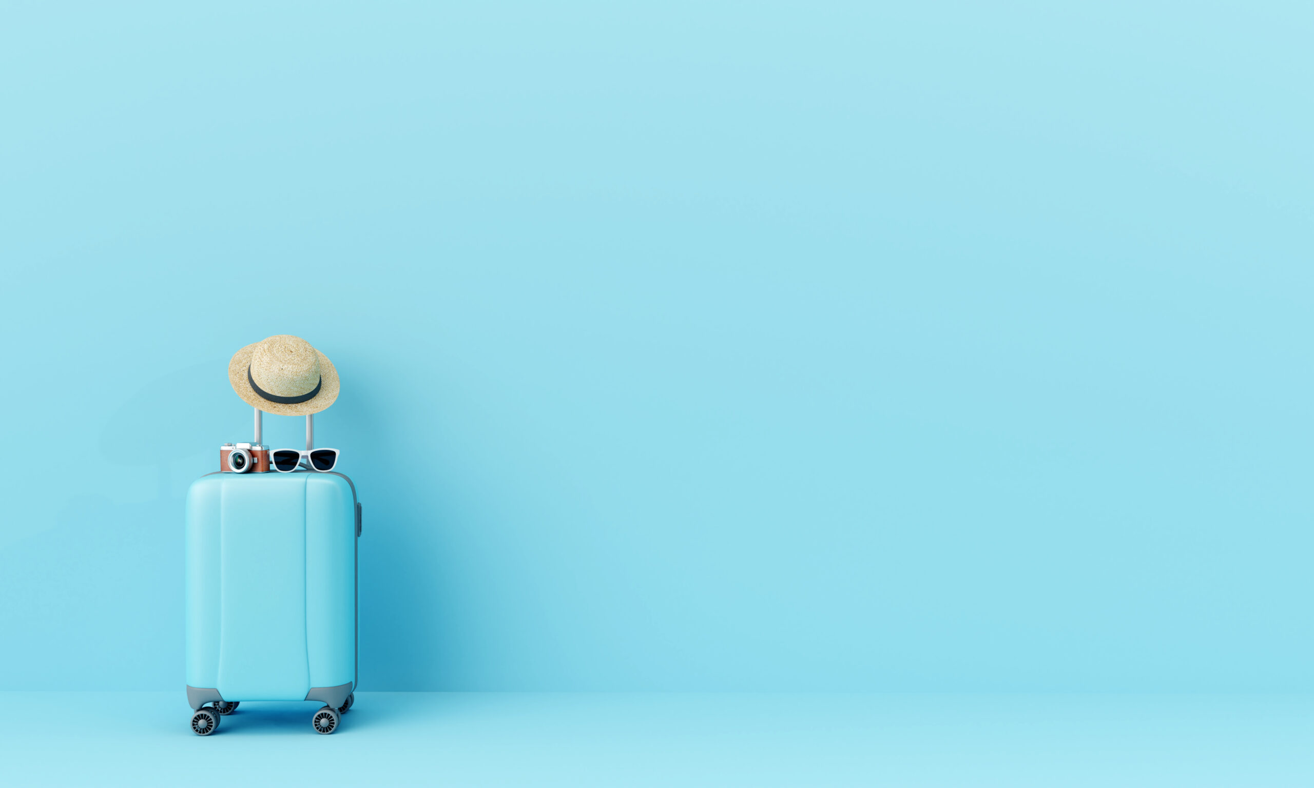 Blue,suitcase,with,sun,glasses,,hat,and,camera,on,pastel